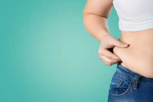 Image of woman pinching her love handles to show weight gain Bracknell